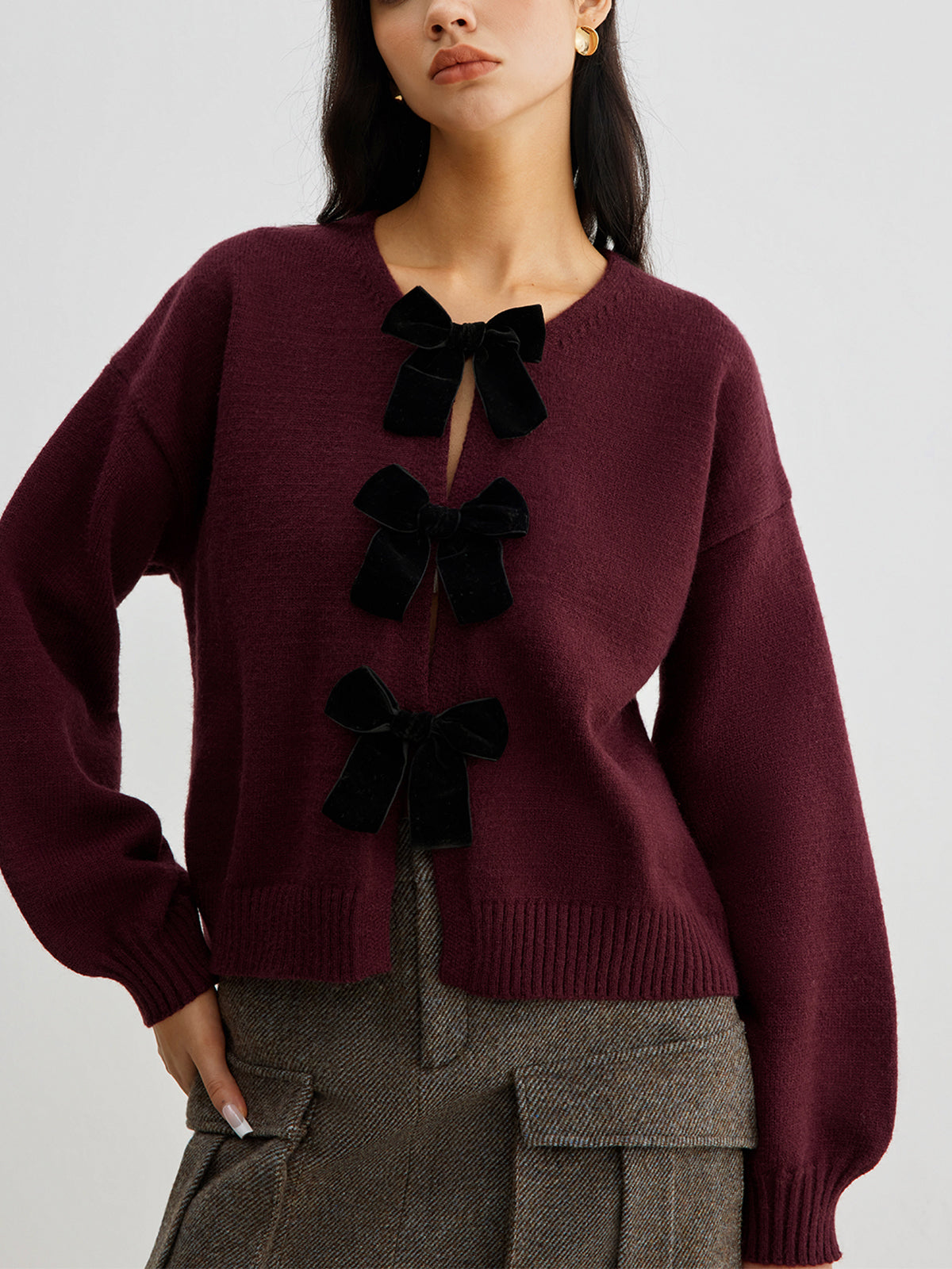 Sweter z ozdobnymi kokardkami na guziki