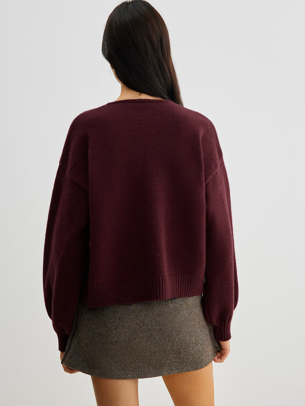 Sweter z ozdobnymi kokardkami na guziki