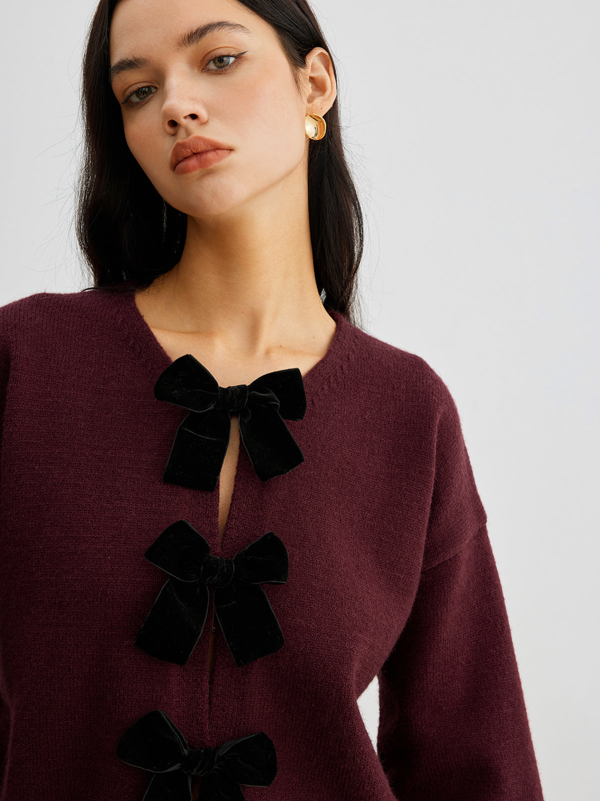 Sweter z ozdobnymi kokardkami na guziki
